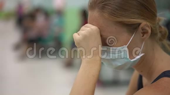 生病的年轻女子坐在医院等待医生预约视频的预览图