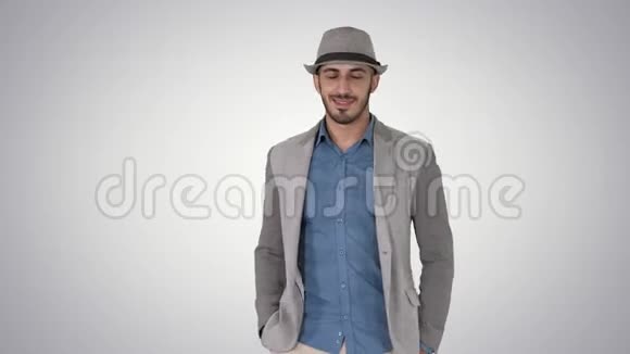 年轻的亚洲游客戴着帽子走着双手插在口袋里背景渐变视频的预览图
