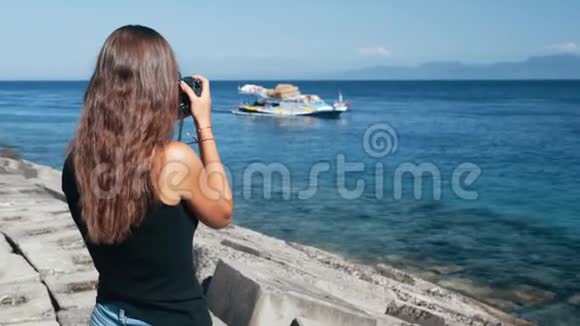女摄影师侧视在专业摄像机上拍摄船上的照片视频的预览图