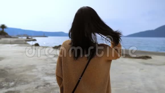 穿着舒适毛衣的女孩可以看到海景视频的预览图