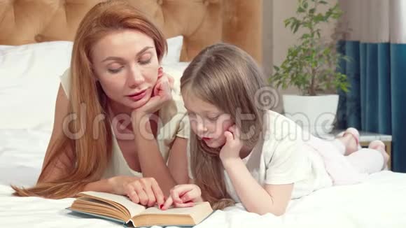 可爱的小女孩在家和妈妈一起读书视频的预览图