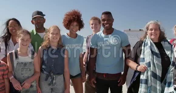 4k阳光下志愿者们站在沙滩上视频的预览图