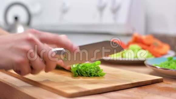 女人用菜刀在木板上切新鲜的洋葱视频的预览图