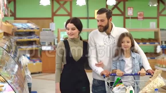 快乐的家庭在大型超市购物他们选择面包和糖果视频的预览图
