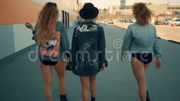 不同的三个女孩朋友正穿着潮流牛仔裤在城市散步时尚叛逆的青少年视频的预览图
