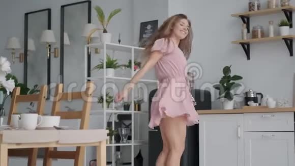 有趣的女孩无忧无虑地在厨房里跳舞和跳跃视频的预览图