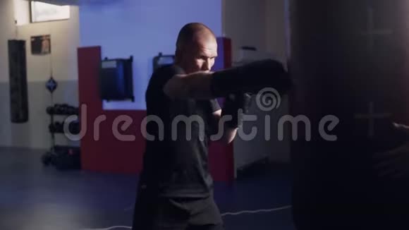 拳击手带着拳击手套在拳击袋上进行打击动作缓慢在健身房训练战斗机视频的预览图