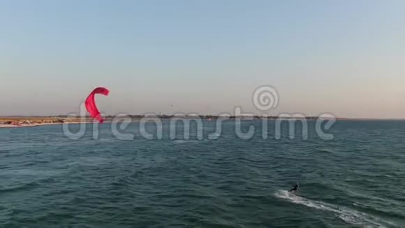 风筝在海中用他的赤鸢在波浪上滑行空中射击视频的预览图