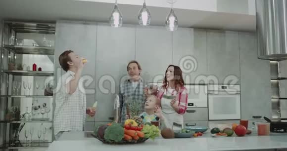 在厨房里一家人在一起玩泡泡和跳舞然后做健康的早餐视频的预览图