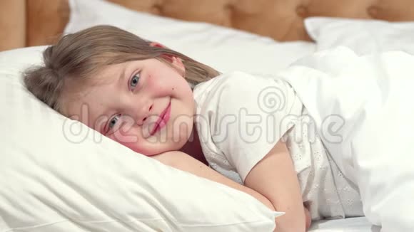 可爱的小女孩要睡在床上妈妈在盖毯子视频的预览图