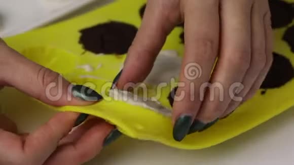 一个女人从硅胶中取出巧克力糖衣视频的预览图