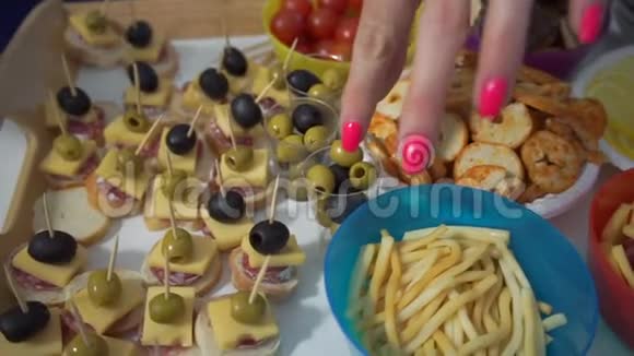 放食物的桌子女孩们用手指拿食物聚会自助餐视频的预览图