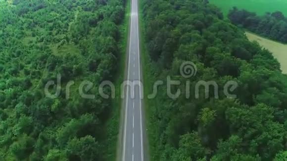 空中俯瞰被茂密的树木和肥沃的田野包围的空路4K视频的预览图
