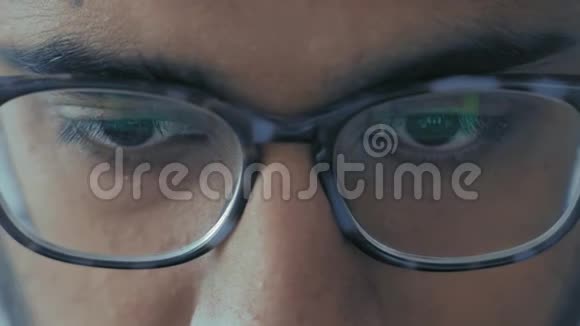特写镜头戴眼镜的印度学生穿着性感的衣服看笔记本显示器视频的预览图