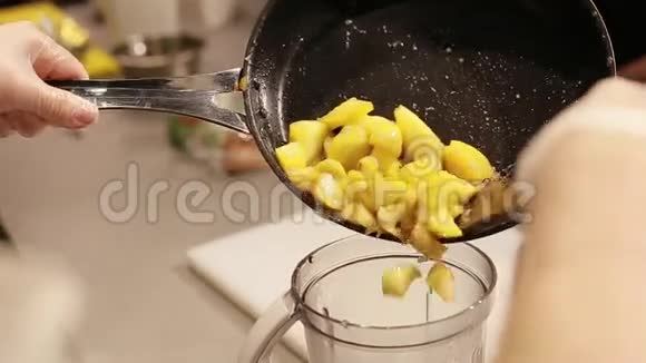 厨师把炒苹果放进搅拌机里视频的预览图