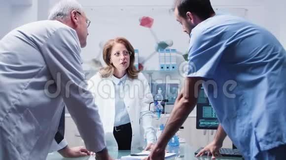 女性和男性科学家和一名助手正在谈话视频的预览图