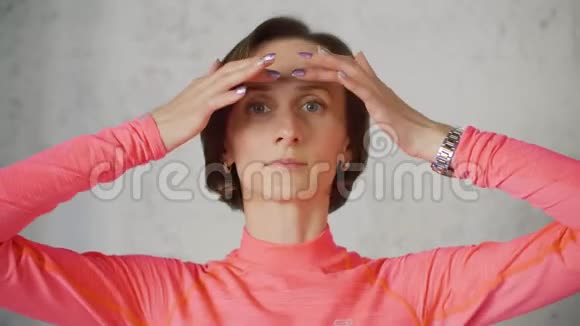 成年女性做面部按摩前摄像头特写女人做皮肤面部按摩为复兴运动模仿体操视频的预览图