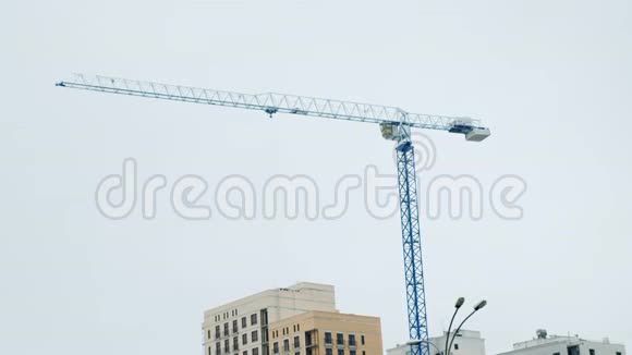 雨天起重机在灰蒙蒙的天空下工作摩天大楼和新大楼的建造过程视频的预览图