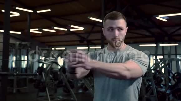 在健身房强壮的人把训练机的手臂朝一个方向拉视频的预览图