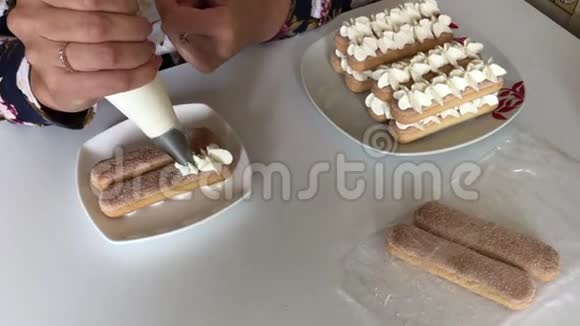 一个女人正在做蛋糕将奶油涂在萨沃亚迪饼干上使用糕点包视频的预览图