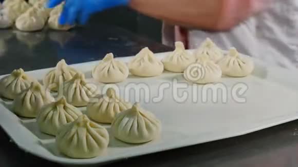 食品视频概念厨师做Khinkali格鲁吉亚民族美食快关门把准备好的饺子放在托盘上4k视频的预览图