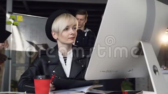 在现代办公室工作的忙碌的年轻商务女性的肖像特写使用电脑触摸屏观看视频的预览图
