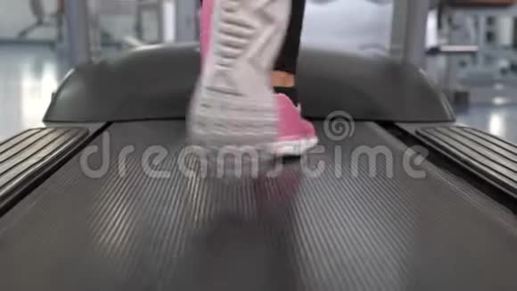 穿运动鞋的女孩的腿在跑步机上行走特写镜头行走时加强腿部肌肉有氧负荷视频的预览图
