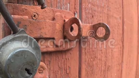 旧木门上的摆动锁带有剥落和划痕油漆的纹理背景视频的预览图