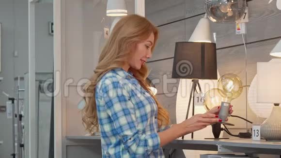 漂亮的女人在家具店为她的公寓买灯饰视频的预览图