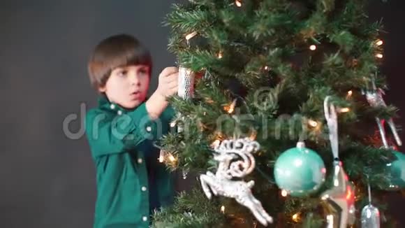 漂亮的孩子把玩具挂在圣诞树上视频的预览图