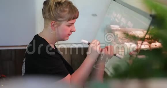 在玻璃上写蛋糕价格的女人视频的预览图