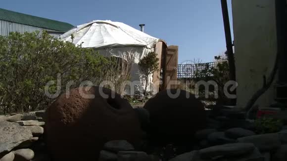 白色帐篷附近的花盆和石头视频的预览图