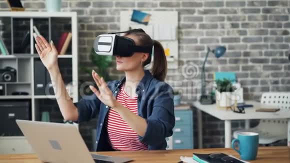 增强现实眼镜办公室工作人员移动双手坐在办公桌上视频的预览图