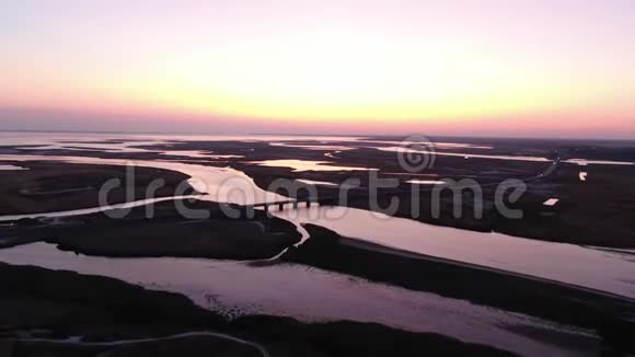 海洋河流和小湖交通桥梁日落的空中镜头视频的预览图