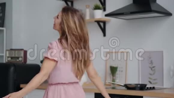 清晨在厨房里跳舞旋转的年轻女人视频的预览图