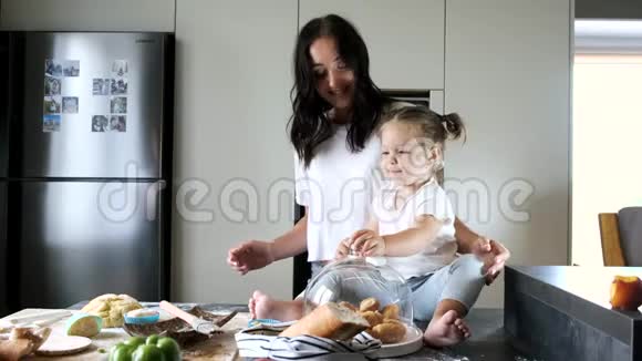 妈妈和女儿在现代厨房里吃自制糖果视频的预览图