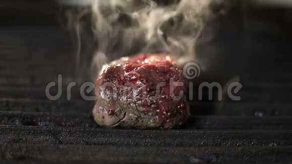 厨师用金属钳子在电烤架上翻转一块鲜肉视频的预览图