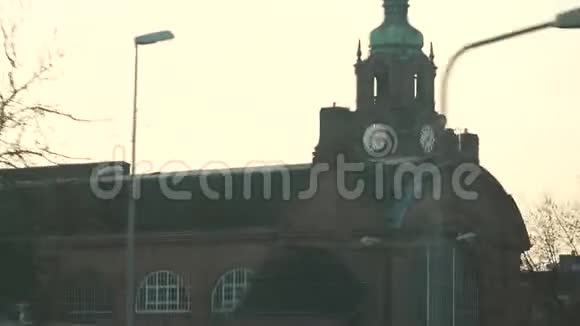 从德国一座历史建筑的公共汽车窗口拍摄火车站钟楼的古建筑视频的预览图