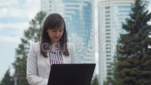 女商人在办公室外使用笔记本电脑视频的预览图