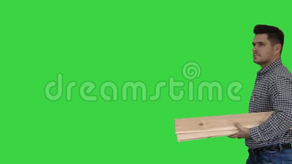 有木板的布鲁内特人建造商准备在绿色屏幕上建造一些东西色度键视频的预览图