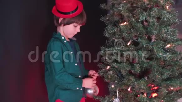 一个孩子把玩具放在圣诞树上视频的预览图