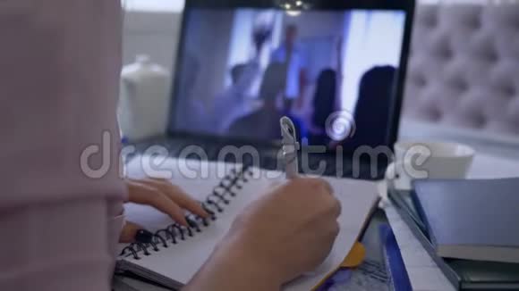 女孩参加视频通话使用笔记本电脑在线教育和远程工作讨论做笔记视频的预览图