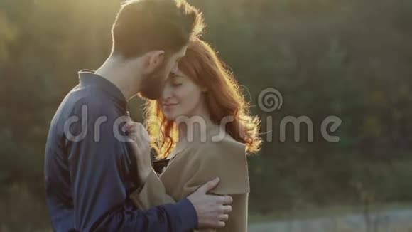 幸福的一对夫妇拥抱在一起在夕阳下亲吻对方视频的预览图
