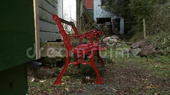 一张农舍外的红色金属长凳视频的预览图