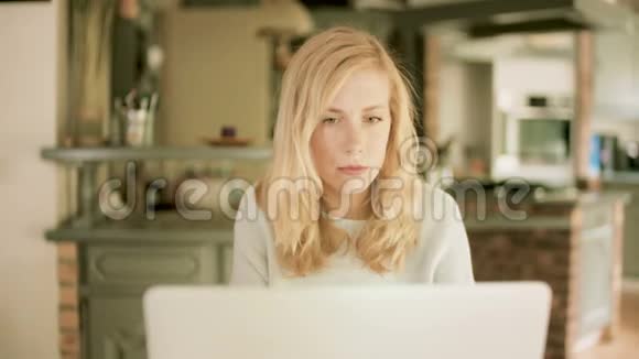 年轻女子看着她的笔记本电脑被她所看到的震惊视频的预览图