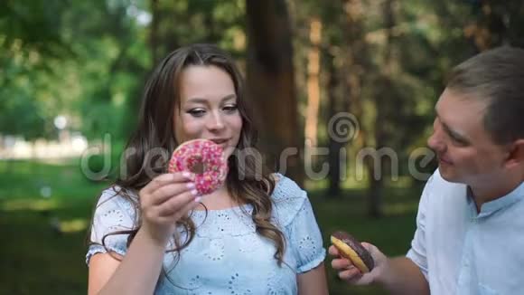 男人和女人在公园玩甜甜圈视频的预览图