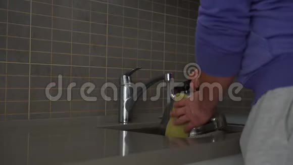 男人在厨房水槽里洗水壶做家务视频的预览图