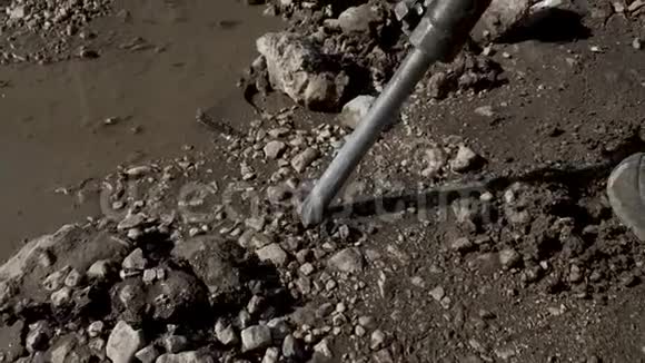 一个人和一个手提钻一起工作一个凿岩机打破了沥青大型和重型道路修复工具慢动作视频的预览图