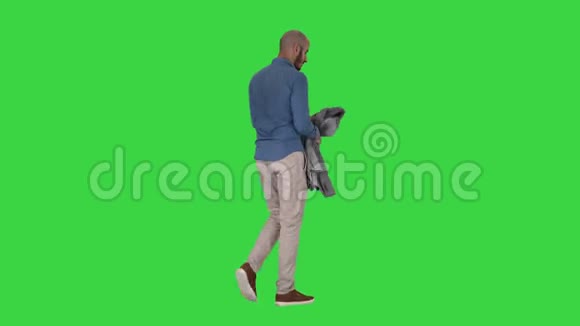 休闲男子穿上夹克在绿色屏幕上变冷Chroma键视频的预览图