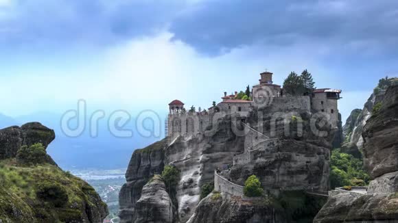 在希腊塞萨里的MeteoraVarlaam修道院游客蜂拥而至云层和阳光照射在岩石上视频的预览图